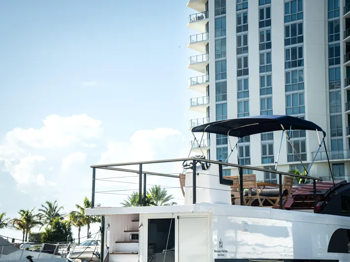  Yacht Photos Pics 2024 Navisyo Homes 28' NAVIS V.08 houseboat docked near modern high-rise building.