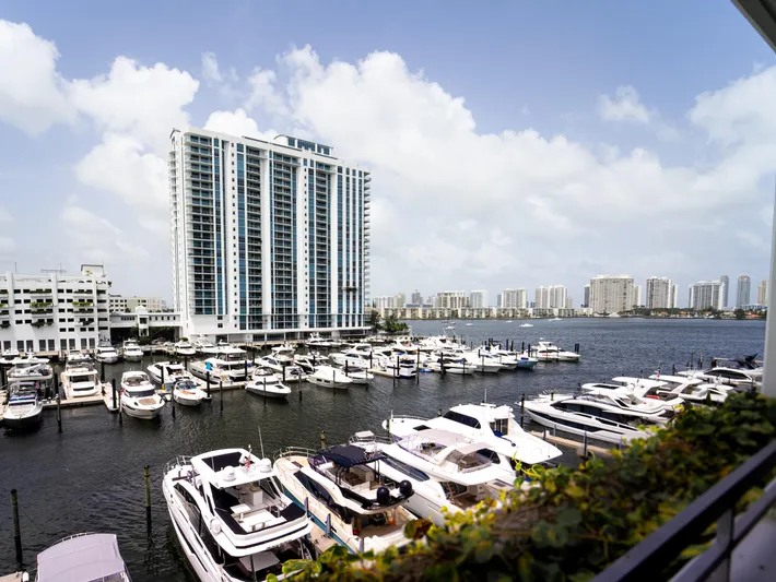  Yacht Photos Pics Marina with luxury yachts, including 2024 Navisyo Homes 28' NAVIS V.08, against city skyline.