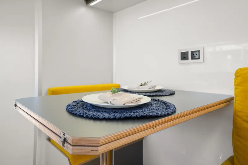  Yacht Photos Pics Modern dining area in 2024 Navisyo Homes 28' NAVIS V.08 with yellow seating and stylish table setting.