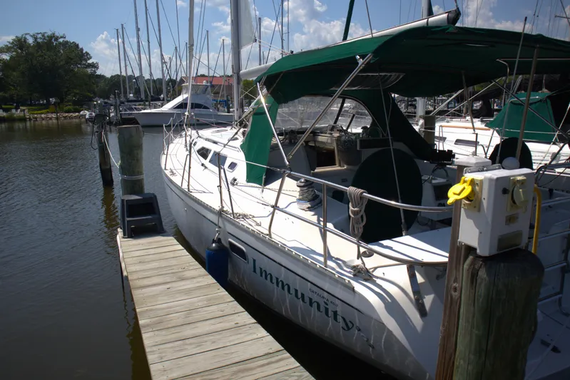 Immunity Yacht Photos Pics 1996 Catalina 400 sailboat docked at marina with green canopy and visible deck equipment.