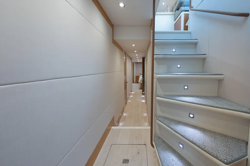 Whistle Yacht Photos Pics Luxurious interior of 2012 Lazzara Breeze yacht, featuring elegant hallway and illuminated staircase.