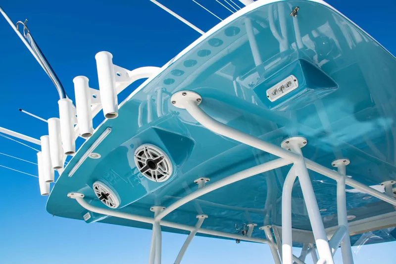  Yacht Photos Pics 2020 SeaVee 370z boat's blue underside with rod holders and speakers against clear sky.