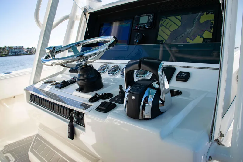 Yacht Photos Pics Control panel of a 2020 SeaVee 370z boat with steering wheel and navigation screens.