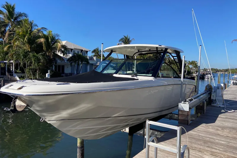  Yacht Photos Pics 2024 Boston Whaler 320 Vantage boat docked by a scenic waterfront.