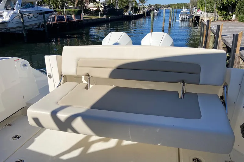 Yacht Photos Pics 2024 Boston Whaler 320 Vantage boat with comfortable seating, docked by a scenic waterfront.