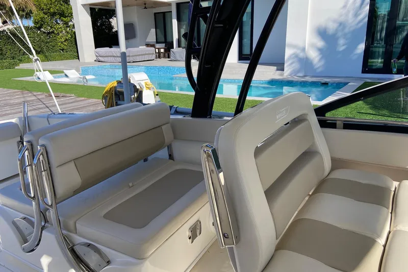  Yacht Photos Pics 2024 Boston Whaler 320 Vantage boat interior near a modern poolside setting.