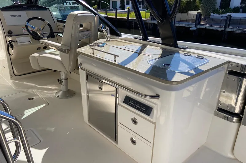  Yacht Photos Pics 2024 Boston Whaler 320 Vantage interior with helm and kitchenette area.