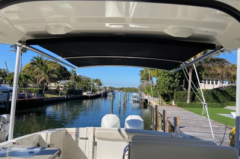  Yacht Photos Pics 2024 Boston Whaler 320 Vantage docked, view of canal and palm trees.