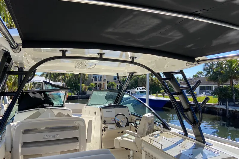  Yacht Photos Pics 2024 Boston Whaler 320 Vantage boat interior with helm, seats, and canopy.