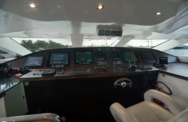  Yacht Photos Pics Control panel of a 2007 Admiral 34m yacht with navigation screens and steering wheel.