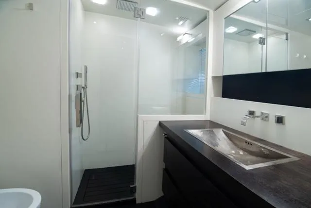  Yacht Photos Pics Modern yacht bathroom with glass shower, sleek sink, and dark wood accents. Admiral 34m, 2007.