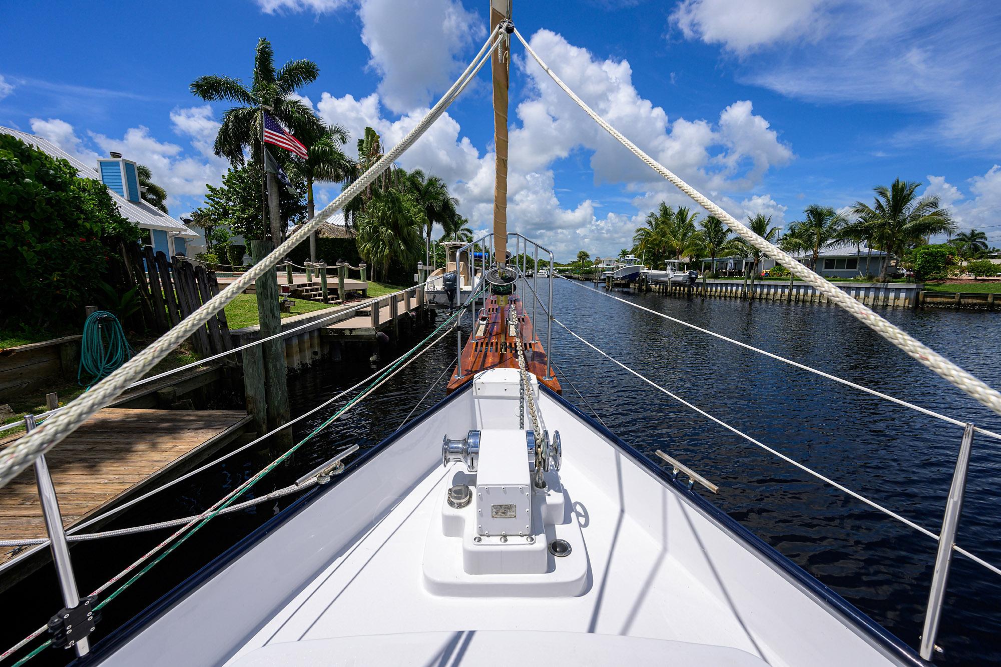 Custom 46 Dennis Schreibert Schooner, 2013, docked by a scenic canal with palm trees.
