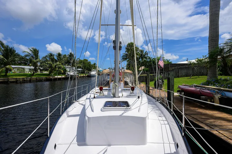 Running On Empty Yacht Photos Pics Custom 46 Dennis Schreibert Schooner, 2013, docked by a scenic canal with palm trees.