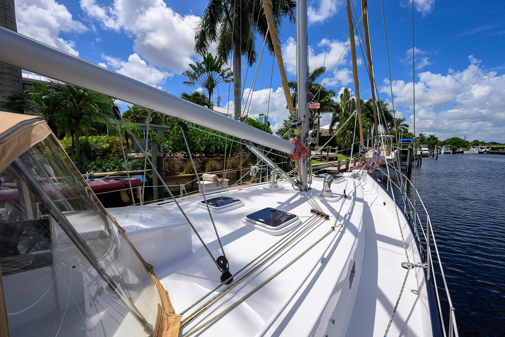 Custom 46 Dennis Schreibert Schooner, 2013, docked by palm trees under a clear blue sky.