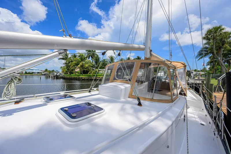 Running On Empty Yacht Photos Pics Custom 46 Dennis Schreibert Schooner, 2013, docked by a scenic waterfront under a clear blue sky.