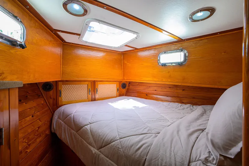 Running On Empty Yacht Photos Pics Cozy cabin interior of 2013 Custom 46 Dennis Schreibert Schooner with wooden paneling and bed.