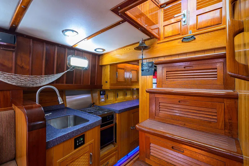 Running On Empty Yacht Photos Pics Luxurious wooden interior of 2013 Custom 46 Dennis Schreibert Schooner with kitchen and stairs.
