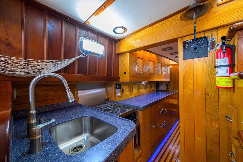 Running On Empty Yacht Photos Pics Luxurious wooden interior of 2013 Custom 46 Dennis Schreibert Schooner kitchen area.