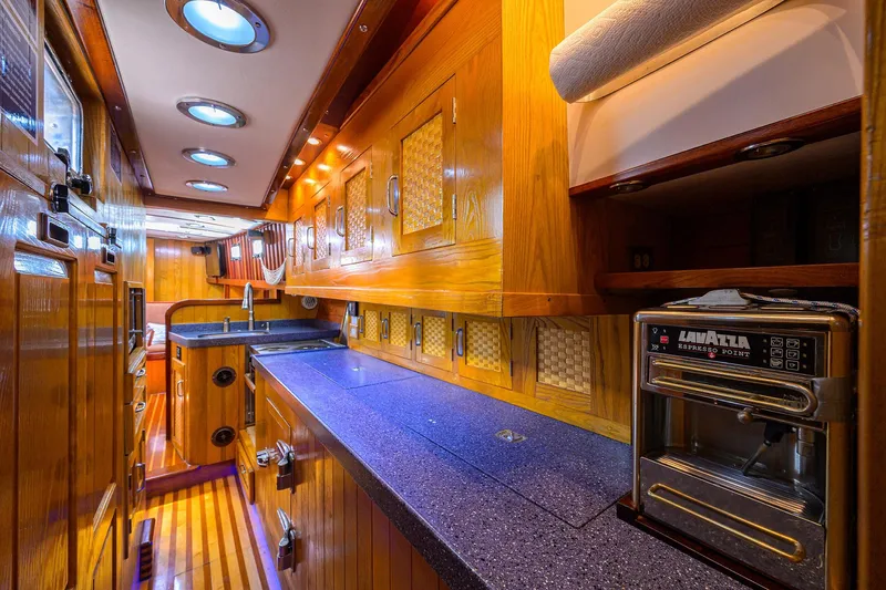 Running On Empty Yacht Photos Pics Luxurious wooden interior of 2013 Custom 46 Dennis Schreibert Schooner kitchen with modern amenities.