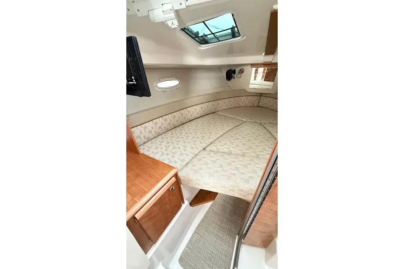  Yacht Photos Pics 2026 Cutwater C-248 Coupe cabin interior with cozy bed and wooden cabinetry.