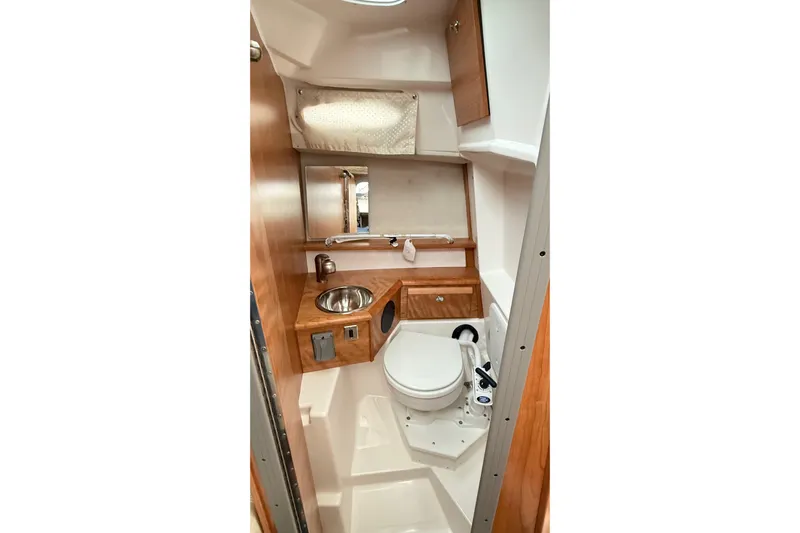  Yacht Photos Pics 2026 Cutwater C-248 Coupe bathroom with wood accents, compact sink, and toilet.
