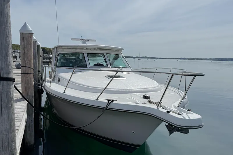  Yacht Photos Pics 2002 Pursuit 3800 Express boat docked on calm water.