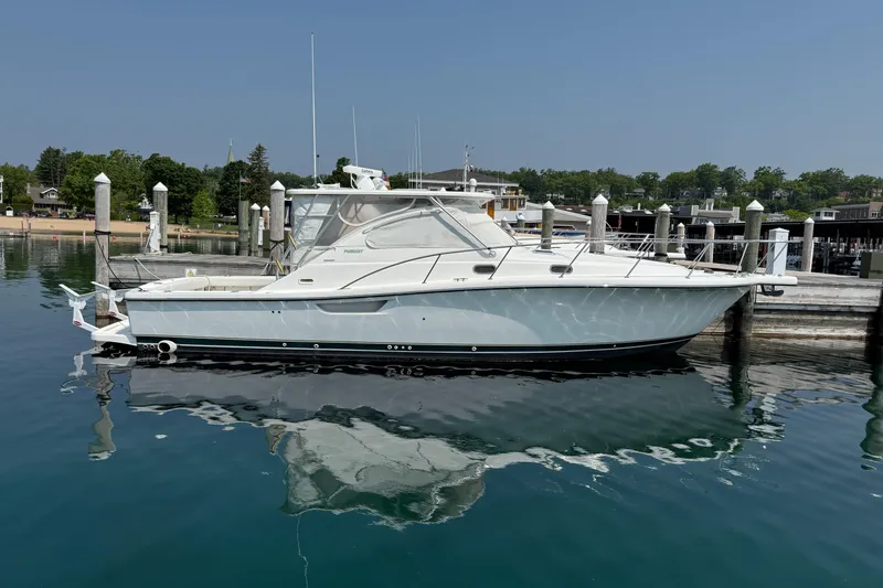  Yacht Photos Pics 2002 Pursuit 3800 Express boat docked in a serene marina setting.