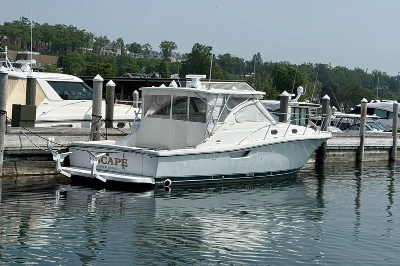  Yacht Photos Pics 2002 Pursuit 3800 Express yacht docked at marina, calm water reflections.
