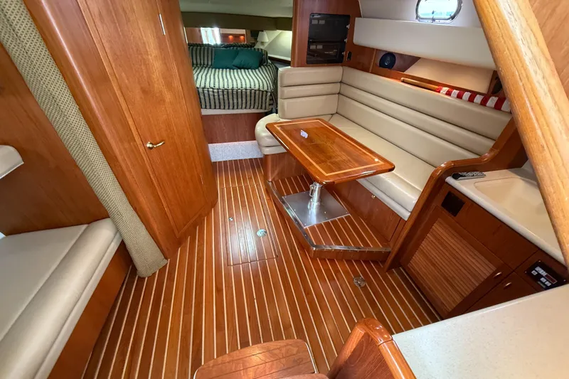  Yacht Photos Pics Interior of 2002 Pursuit 3800 Express yacht with wood flooring and cozy seating area.