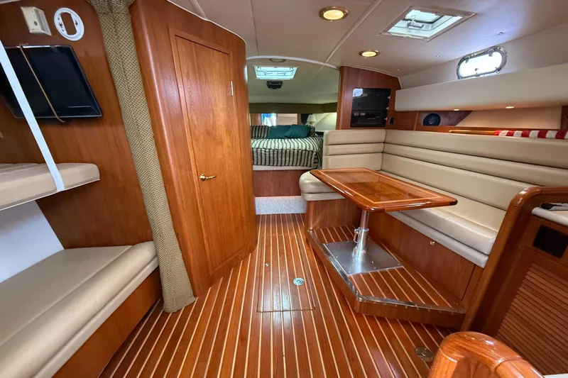  Yacht Photos Pics Interior of 2002 Pursuit 3800 Express yacht with wood flooring and cozy seating area.
