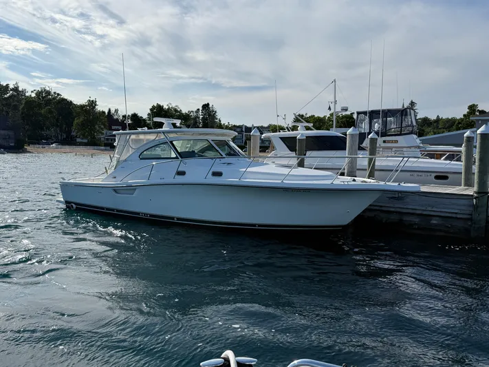  Yacht Photos Pics 2002 Pursuit 3800 Express boat docked at marina, calm water, partly cloudy sky.