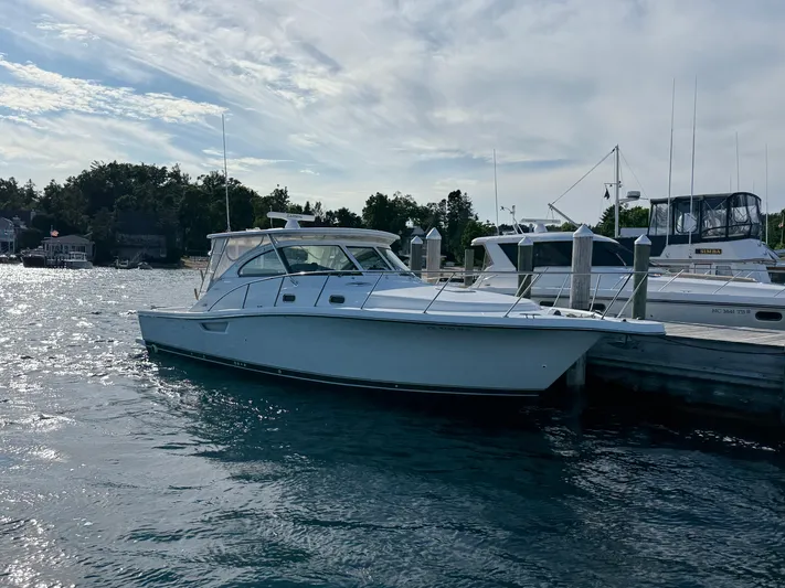  Yacht Photos Pics 2002 Pursuit 3800 Express boat docked at marina under cloudy sky.