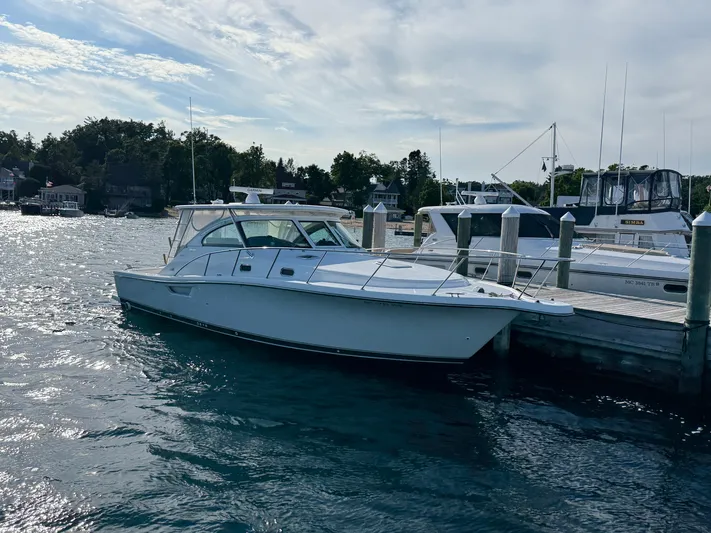  Yacht Photos Pics 2002 Pursuit 3800 Express yacht docked at marina, calm water, clear sky.
