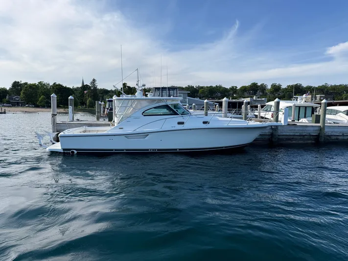  Yacht Photos Pics 2002 Pursuit 3800 Express yacht docked at marina, calm water, clear sky.