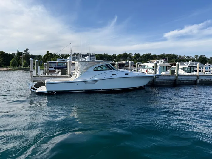  Yacht Photos Pics 2002 Pursuit 3800 Express yacht docked at marina, calm water, clear sky.