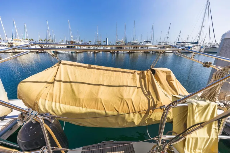 Maka Le'a Yacht Photos Pics Covered dinghy on a 2006 Jeanneau DS sailboat, docked in a marina.