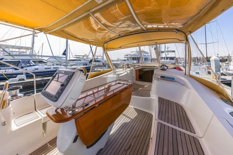 Maka Le'a Yacht Photos Pics 2006 Jeanneau DS yacht interior with wooden deck and navigation equipment in marina.