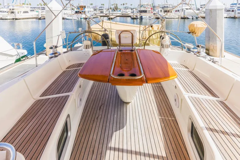Maka Le'a Yacht Photos Pics 2006 Jeanneau DS yacht cockpit with wooden table, docked at marina.