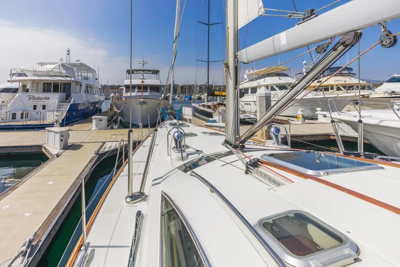 Maka Le'a Yacht Photos Pics 2006 Jeanneau DS sailboat docked among luxury yachts in a marina.