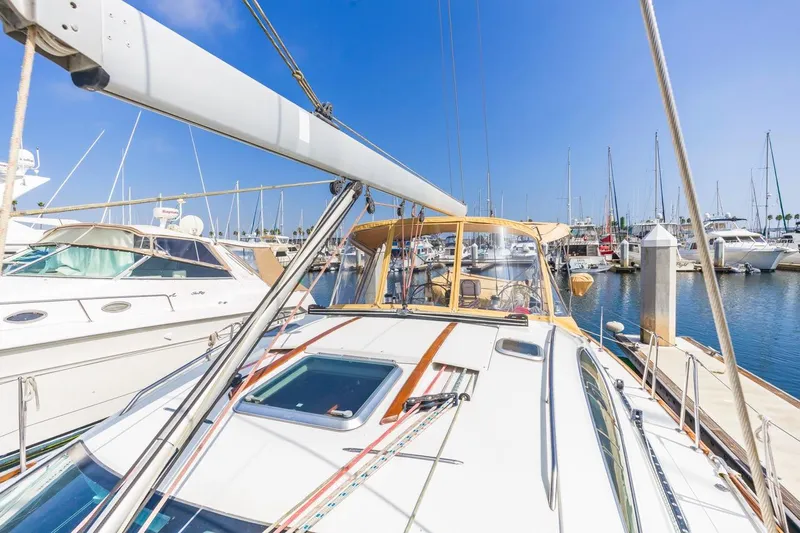 Maka Le'a Yacht Photos Pics 2006 Jeanneau DS sailboat docked in a sunny marina, surrounded by other boats.