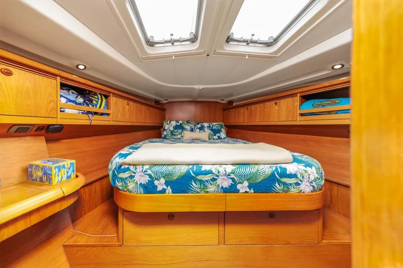 Maka Le'a Yacht Photos Pics Cozy cabin interior of 2006 Jeanneau DS yacht with floral bedding and wooden finish.