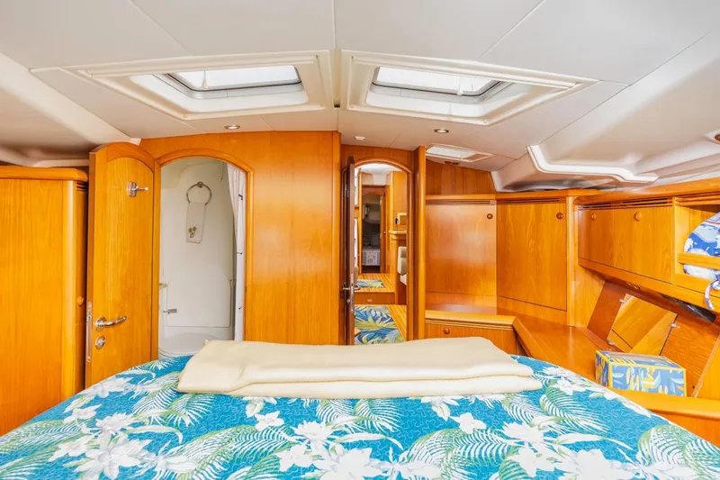 Maka Le'a Yacht Photos Pics Luxurious 2006 Jeanneau DS yacht cabin with wooden interior and floral bedding.