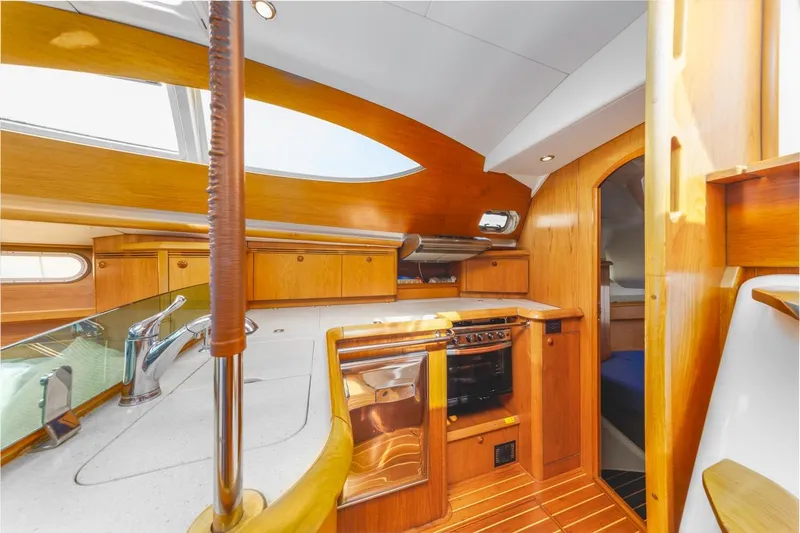 Maka Le'a Yacht Photos Pics Interior of 2006 Jeanneau DS yacht with wooden cabinetry and modern kitchen amenities.