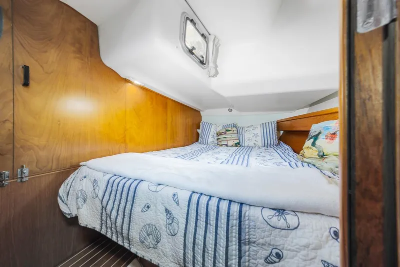 Maka Le'a Yacht Photos Pics Cozy cabin interior of 2006 Jeanneau DS yacht with nautical-themed bedding.