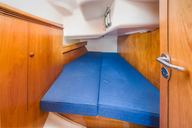 Maka Le'a Yacht Photos Pics 2006 Jeanneau DS cabin interior with blue mattress and wooden cabinetry.