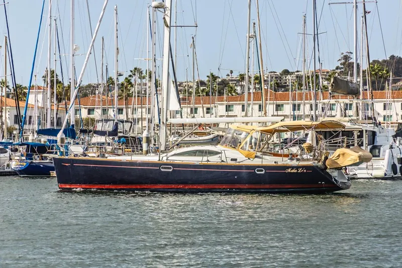 Maka Le'a Yacht Photos Pics 2006 Jeanneau DS sailboat docked in a marina with other boats.
