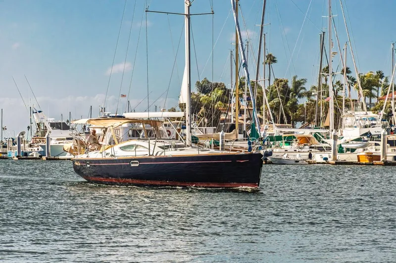 Maka Le'a Yacht Photos Pics 2006 Jeanneau DS sailboat cruising in a marina with other boats docked nearby.