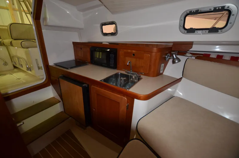 Able II Yacht Photos Pics 2008 Hunt Yachts Surfhunter 29 interior with kitchenette, sink, microwave, and seating area.