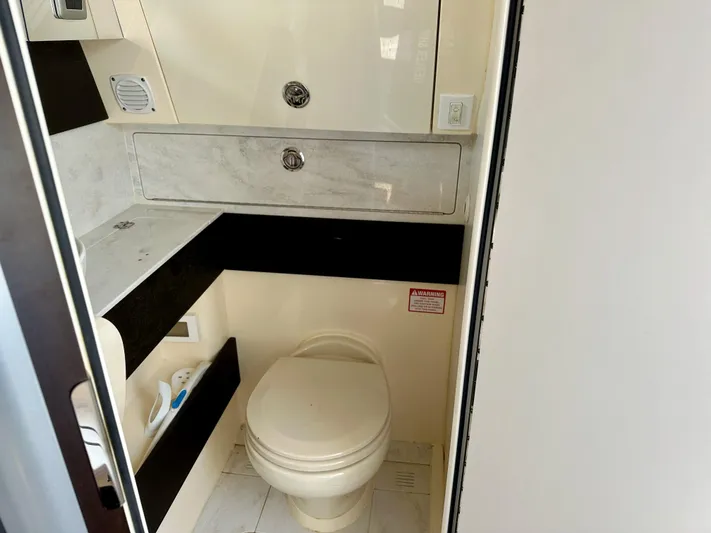  Yacht Photos Pics 2019 Scout 380 LXF boat bathroom with toilet and storage cabinets.