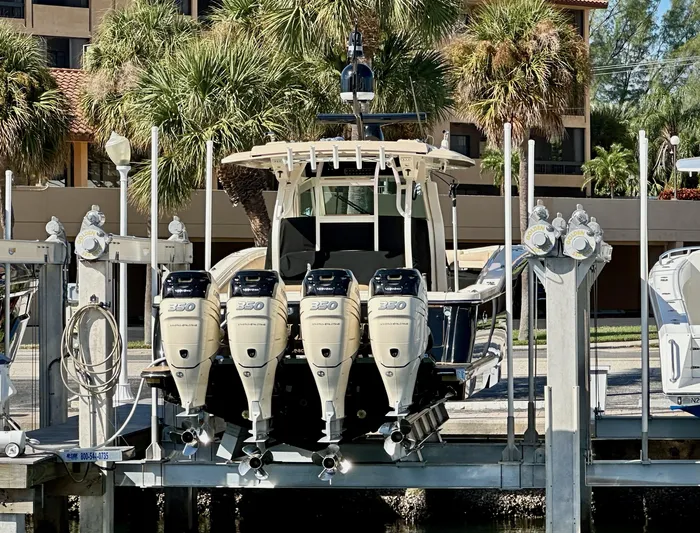  Yacht Photos Pics 2019 Scout 380 LXF boat with four powerful engines docked near palm trees.